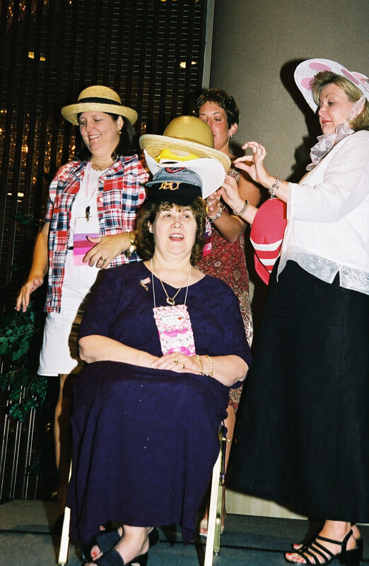 Cathy Moore Placing Hat on Mary Jane Johnson at Convention Officers' Luncheon Photograph, July 4-8, 2002 (Image)