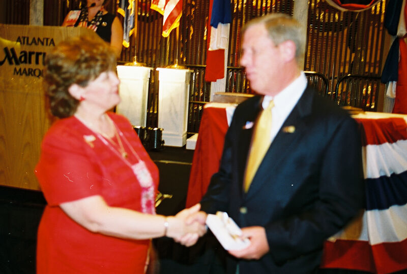 Mary Jane Johnson Presenting Gift to Johnny Isakson at Convention Welcome Dinner Photograph 2, July 4, 2002 (Image)