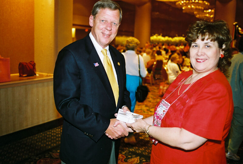 Mary Jane Johnson Presenting Gift to Johnny Isakson at Convention Welcome Dinner Photograph 3, July 4, 2002 (Image)
