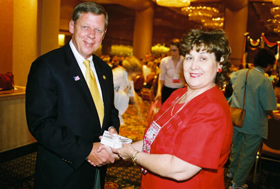 Mary Jane Johnson Presenting Gift to Johnny Isakson at Convention Welcome Dinner Photograph 4, July 4, 2002 (image)