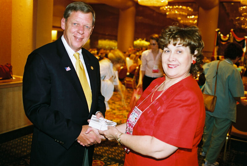 Mary Jane Johnson Presenting Gift to Johnny Isakson at Convention Welcome Dinner Photograph 4, July 4, 2002 (Image)