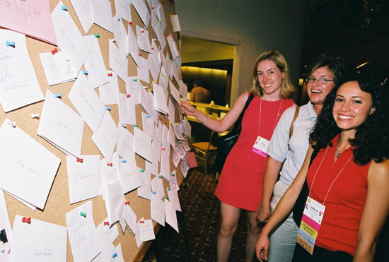 Three Phi Mus by Bulletin Board at Convention Photograph 1, July 4-8, 2002 (image)