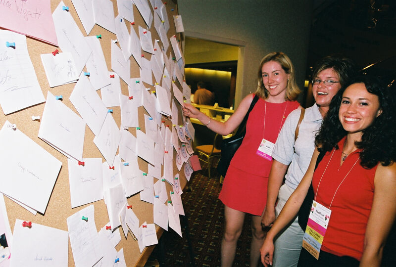 Three Phi Mus by Bulletin Board at Convention Photograph 1, July 4-8, 2002 (Image)