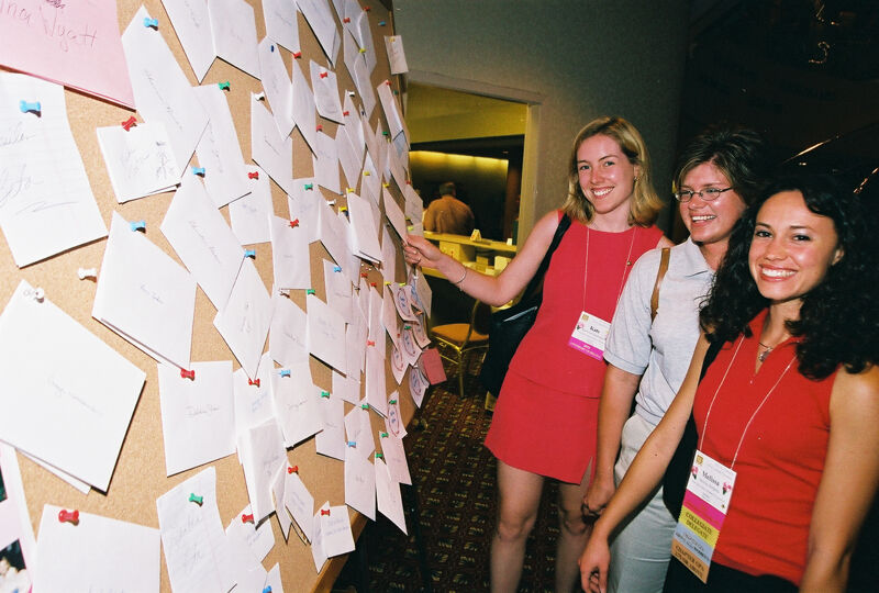 Three Phi Mus by Bulletin Board at Convention Photograph 2, July 4-8, 2002 (Image)