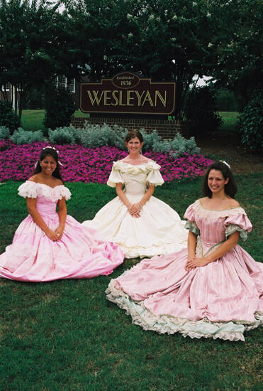 Three Phi Mus in Period Dress by Wesleyan Sign at Convention Photograph 5, July 4-8, 2002 (image)