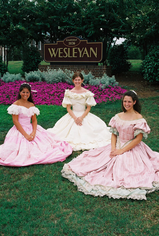 Three Phi Mus in Period Dress by Wesleyan Sign at Convention Photograph 1, July 4-8, 2002 (Image)