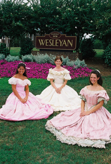 Three Phi Mus in Period Dress by Wesleyan Sign at Convention Photograph 2, July 4-8, 2002 (image)