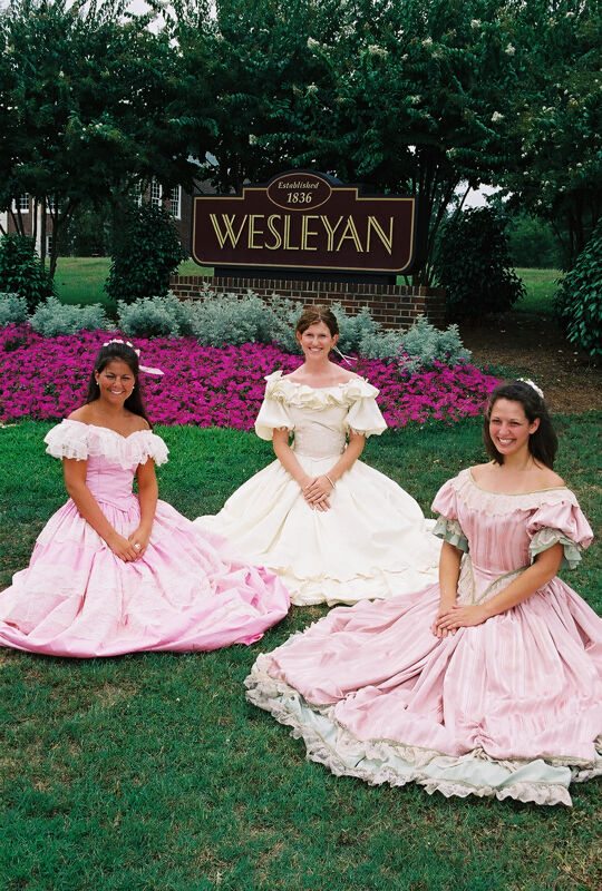 Three Phi Mus in Period Dress by Wesleyan Sign at Convention Photograph 2, July 4-8, 2002 (Image)