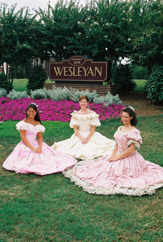 Three Phi Mus in Period Dress by Wesleyan Sign at Convention Photograph 6, July 4-8, 2002 (Image)