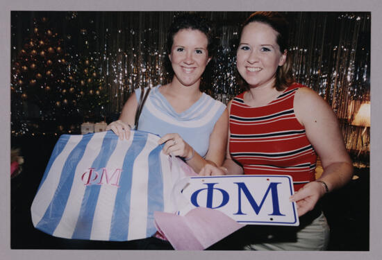 Two Members With Phi Mu Merchandise at Convention Photograph 1, July 4-8, 2002 (image)