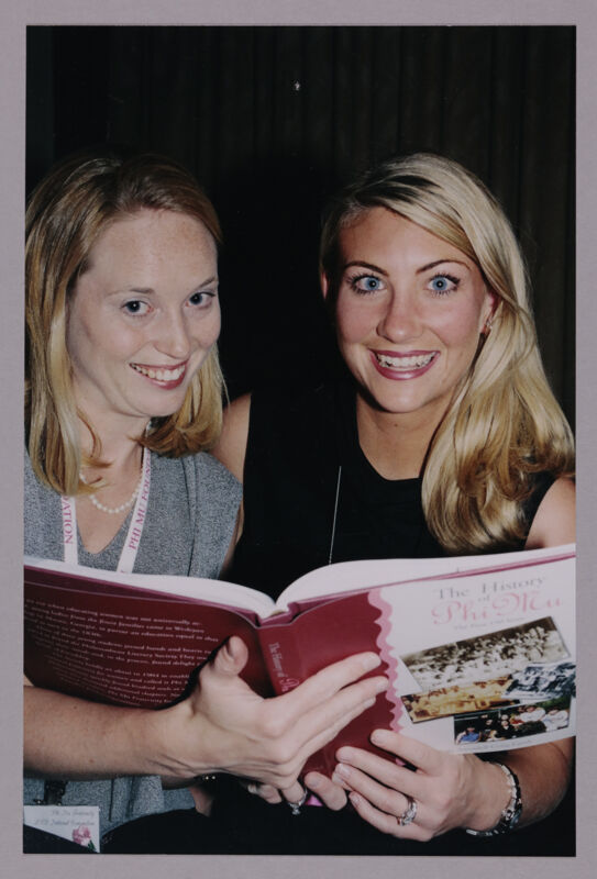 Two Phi Mus Reading History Book at Convention Photograph, July 4-8, 2002 (Image)