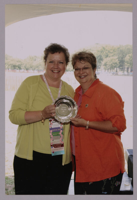 Audrey Jankucic and Kathy Williams With Award at Convention Outdoor Luncheon Photograph 1, July 10, 2004 (Image)