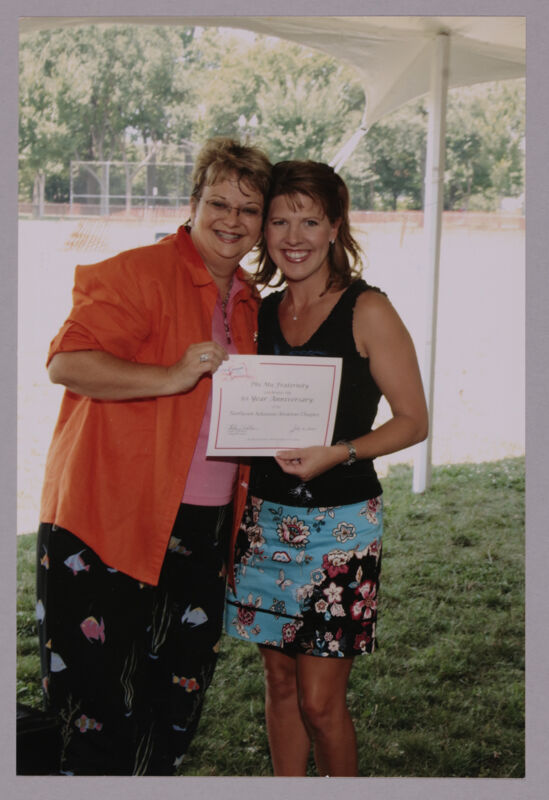 Kathy Williams and Northeast Arkansas Alumna With Certificate at Convention Outdoor Luncheon Photograph 1, July 10, 2004 (Image)
