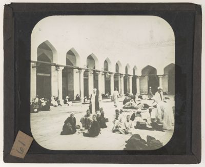 [Men setting in a mosque's courtyard]
