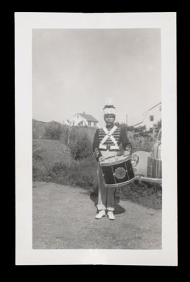 [A Man in Marching Band Uniform, Holding a Drum]