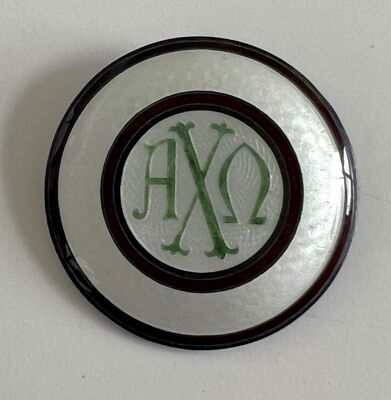 Round enamel pin with Alpha Chi Omega Greek letters belonging to Founder Olive Burnett Clark