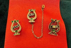 Examples of badges with emeralds, early 1900s