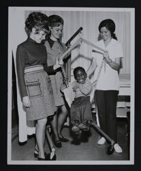 Alumnae with Child Using Therapy Equipment Photograph, c. 1970