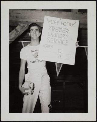 Camp Staff Member Holding Laundry Sign Photograph, c. July 1940
