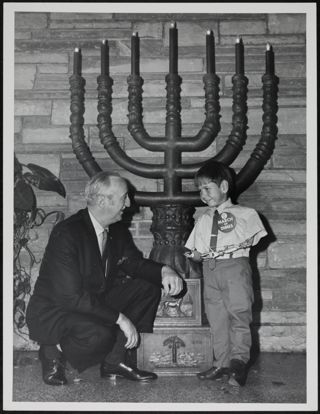 Child With Prosthetic Arms With March of Dimes Button in Front of Menora Photograph