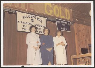 Three BBG Members Standing With Flowers at International Convention Photograph, 1984