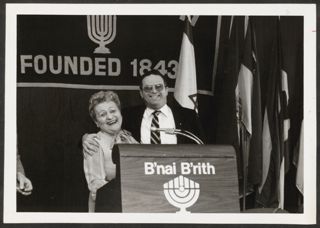 Anita Perlman and Moishe Hamburg Smiling at Podium Photograph