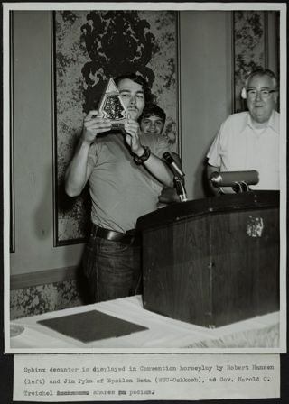 Robert Hansen Displaying Sphinx Decanter Photograph, 1971