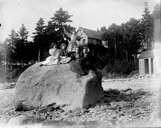 Group of girls on big rock on beach at Shady Nook, Trenton, Maine.