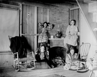Four girls near fireplace in cottage at Shady Nook.