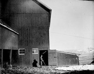 Arthur by door in Hobart's barn yard. Looking west to door.