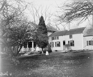 In back yard of parsonage looking toward house. Frances Yale holding cat near kitchen door.