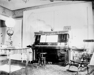 Parlor showing piano, center table and rocking chair