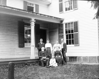 Group, before dining room door with Ruth sitting on grass