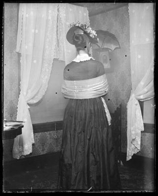 Annie Persis Woodward in old-fashioned costume shown from the back