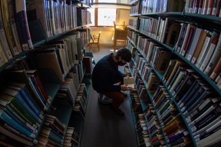 Student browsing in the Thorndike Library stacks
