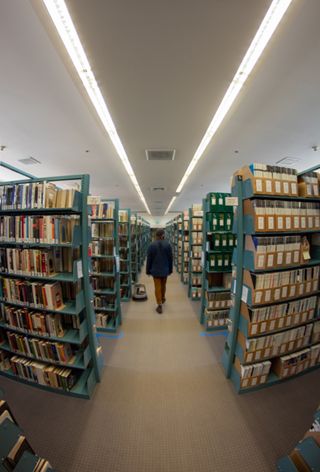Student walking in the Thorndike Library stacks