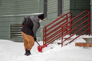 Student Hayden Platteter shoveling snow