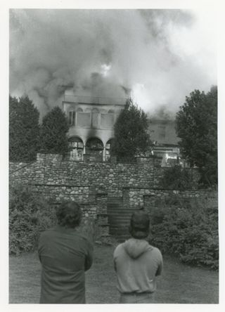 Two look on as Kaelber Hall is engulfed in flames