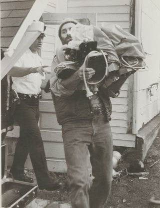 Steve Katona carrying lab equipment