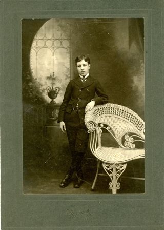 Portrait of boy in dark suit with white shirt