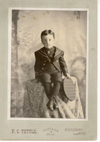 Boy in dark sailor suit holding hat