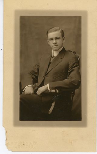 Man in suit seated in chair