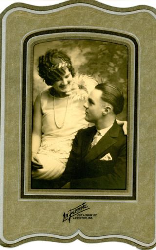 Woman in flapper dress seated next to man in dark suit