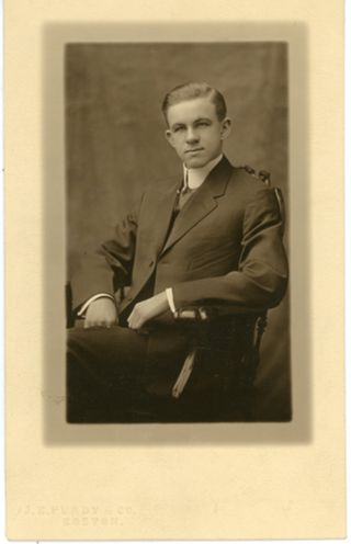 Man in suit seated in chair with large white collar