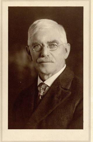 Man with grey hair wearing dark suit