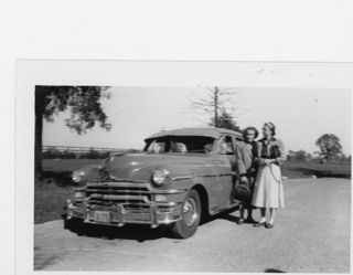 Two women standing next to 1940.50 Packard car.