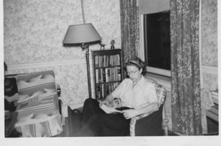 B&W photograph of a LaRue Spiker sitting in a chair reading a book