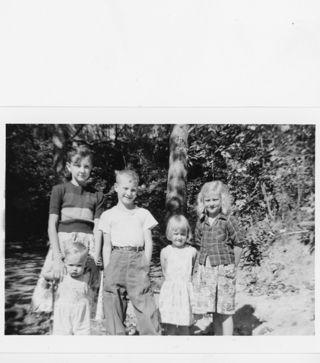 B&W photograph of a cabin in the trees