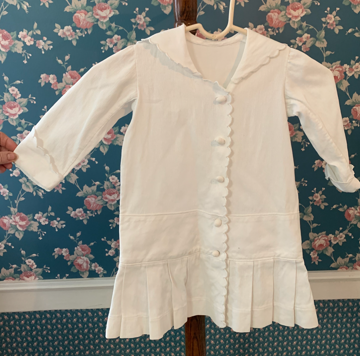 Buttoned dress with pleated skirt, cuffs, and wide collar