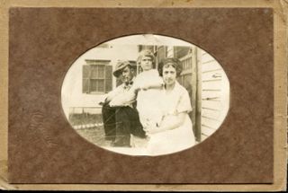 Allan Stanley & Mildred Hopkins sitting on doorstep with child